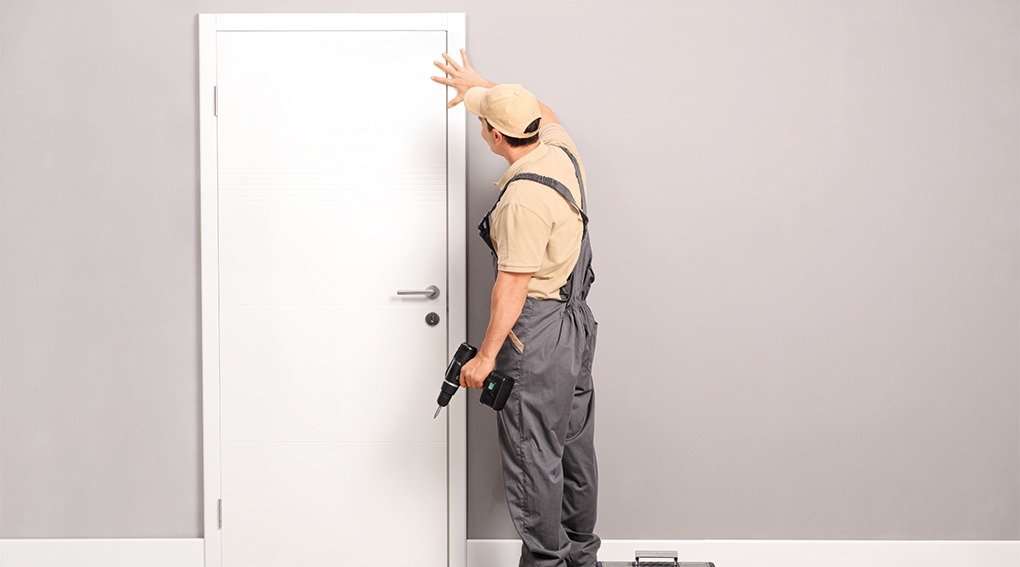 Un homme pose une porte intérieure